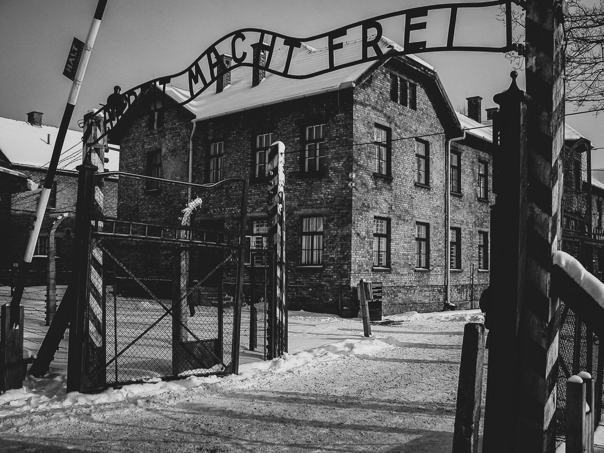 Auschwitz concentration camp entrance gate with the Arbeit Macht Frei sign in the snow.